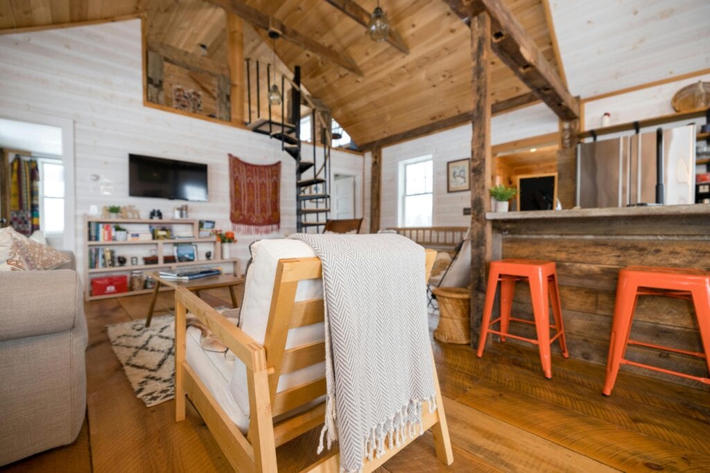 A modern living room with a soft couch, a chair, and a TV, designed for comfort and leisure activities.